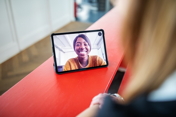 photo of a person using a tablet with video conferencing